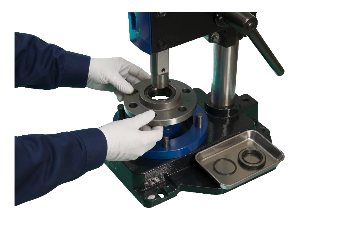 White-gloved technicians seating a wheel-hub bearing assembly in a dedicated press fixture